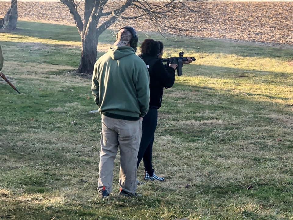 NRA certified firearms instructor coaching a student on rifle handling during outdoor training in Fallston, Maryland.