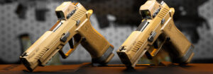 SIG Sauer M17 and M18 pistols in coyote-tan finish with optics installed, displayed side-by-side for comparison