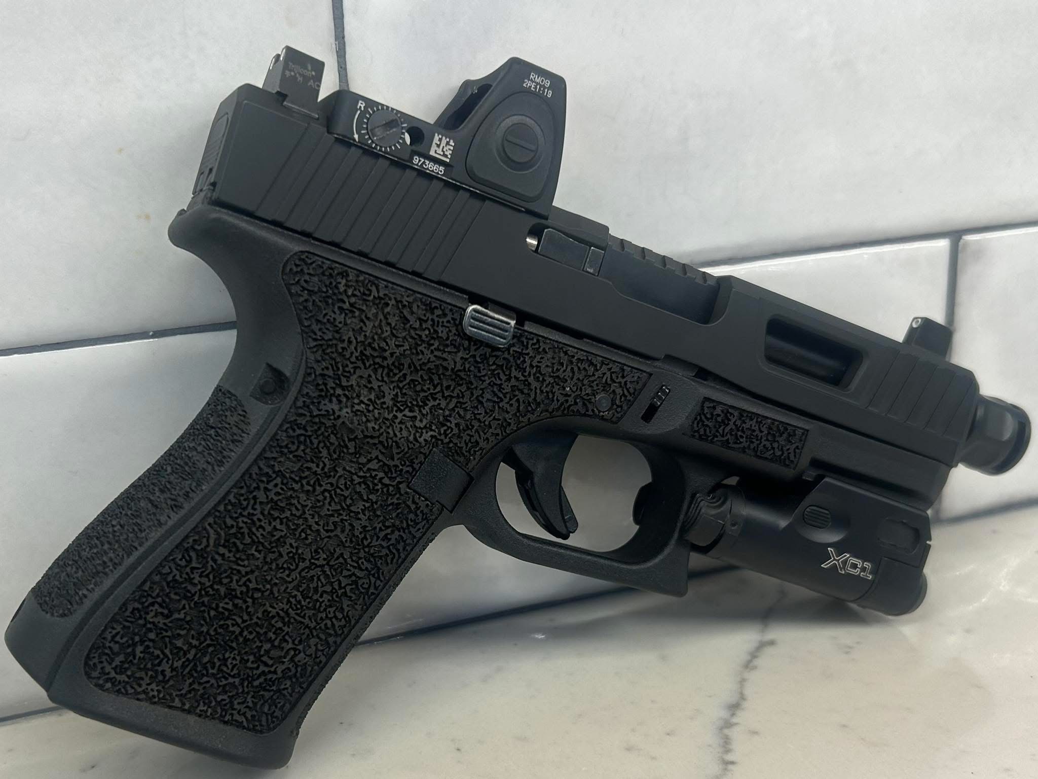 Custom Glock Stippling and Frame work displayed on tile surface.
